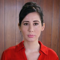 Cheryl Harris Unsmiling woman with dark hair in an updo